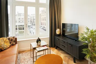 a living room with a large window and a television at Damrak Short Stay Amsterdam in Amsterdam