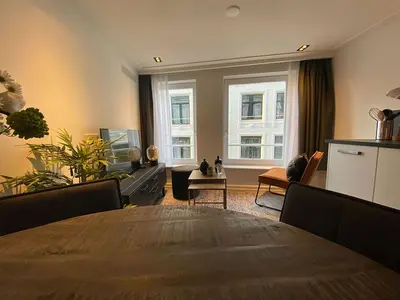 a living room with a wooden table and a dining room tablektop at Damrak Short Stay Amsterdam in Amsterdam