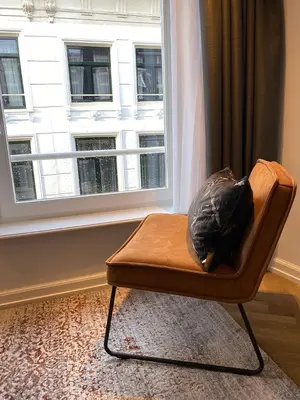 a chair sitting in front of a window at Damrak Short Stay Amsterdam in Amsterdam