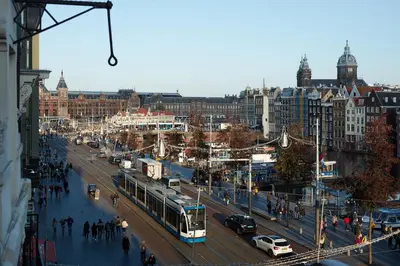 a city street with a bus on a busy street at Damrak Short Stay Amsterdam in Amsterdam