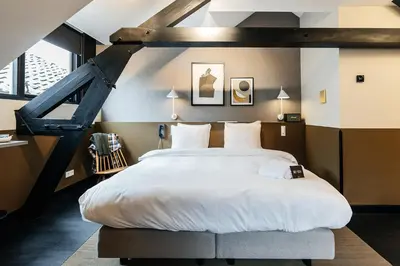 a bedroom with a large white bed in a loft at The Hunfeld in Utrecht