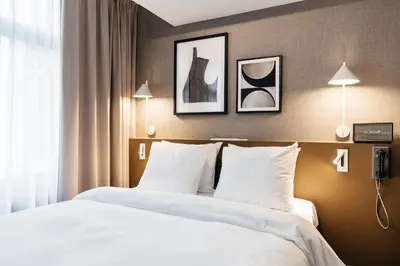a bedroom with a bed with white sheets and pillows at The Hunfeld in Utrecht