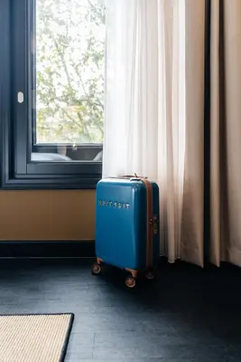 a blue suitcase sitting in front of a window at The Hunfeld in Utrecht