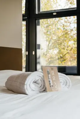 a pile of towels sitting on a bed with a window at The Hunfeld in Utrecht