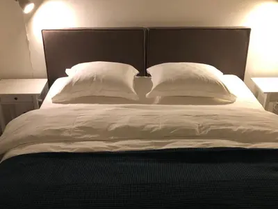 a large bed with white sheets and pillows at B&B Mondriaan in Amsterdam