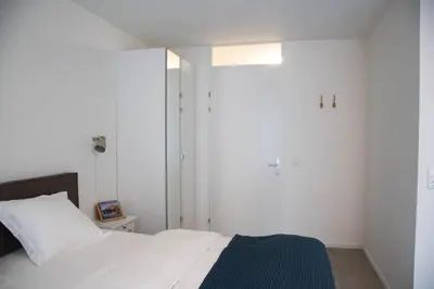 a bedroom with a white bed and a blue blanket at B&B Mondriaan in Amsterdam