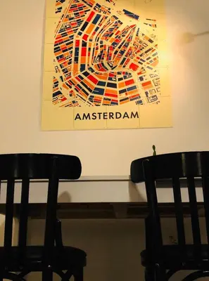 a painting on a wall next to two chairs at B&B Mondriaan in Amsterdam