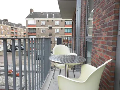 a balcony with chairs and a table and a building at B&B Mondriaan in Amsterdam
