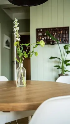 a vase with flowers sitting on a wooden table at Traditional family apartment with garden at countryside Amsterdam in Landsmeer