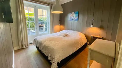 a small bedroom with a bed and a window at Traditional family apartment with garden at countryside Amsterdam in Landsmeer