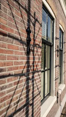 a brick wall with a statue on a building at Traditional family apartment with garden at countryside Amsterdam in Landsmeer