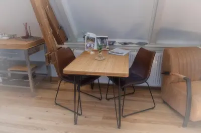 a wooden table and chairs in a room at Com-In in Alkmaar