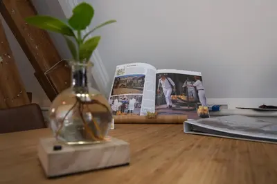 a vase on a table with a book and a plant at Com-In in Alkmaar
