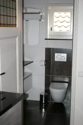 a small bathroom with a toilet and a window at Com-In in Alkmaar