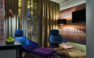 two blue chairs in a room with a table at Clayton Hotel Amsterdam American in Amsterdam