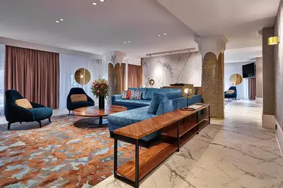 a living room with a blue couch and chairs at Clayton Hotel Amsterdam American in Amsterdam