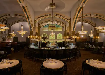 a dining room with tables and chairs and chandeliers at Clayton Hotel Amsterdam American in Amsterdam