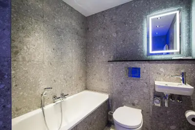 a bathroom with a tub and a sink and a toilet at Clayton Hotel Amsterdam American in Amsterdam