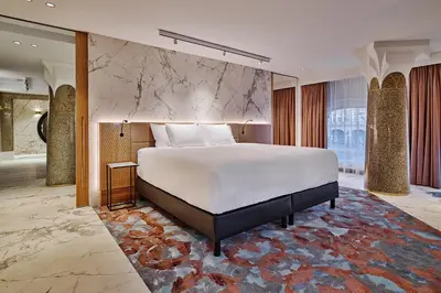 a bedroom with a large bed and a rug at Clayton Hotel Amsterdam American in Amsterdam