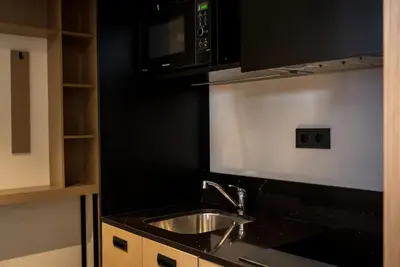 a kitchen with a sink and a microwave at Executive Residency by Best Western Amsterdam Airport in Hoofddorp