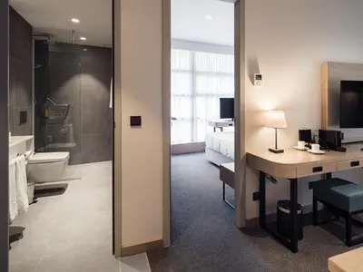 a hotel room with a bathroom with a toilet and a desk at Executive Residency by Best Western Amsterdam Airport in Hoofddorp