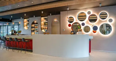 a bar in a restaurant with a counter and chairs at Executive Residency by Best Western Amsterdam Airport in Hoofddorp