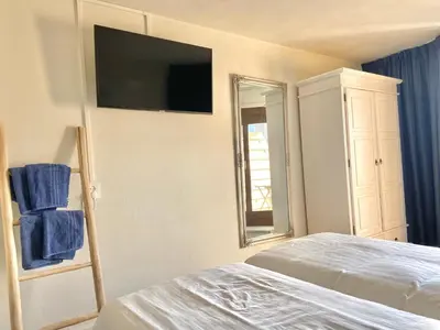 a bedroom with a bed and a television on the wall at Bed & Ontbijt Haddock in Almere