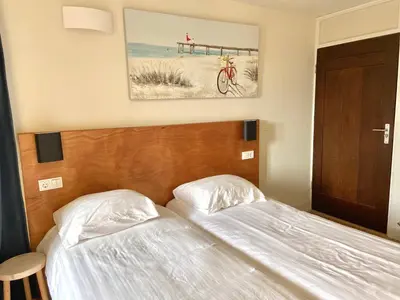 a bedroom with two beds and a bike on the wall at Bed & Ontbijt Haddock in Almere