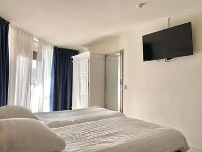 a bedroom with a bed and a flat screen tv at Bed & Ontbijt Haddock in Almere