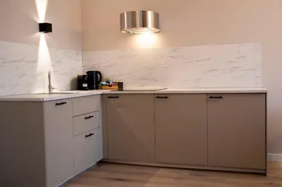 a kitchen with white marble countertops and a sink at Grand Central Suites in Zandvoort