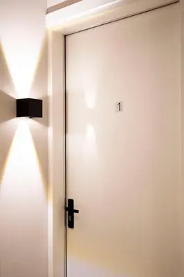 a door with the number on it next to a lamp at Grand Central Suites in Zandvoort