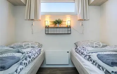 two beds in a room with a window at D'azur in Aalsmeer