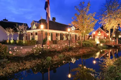 a house with lights on the water at night at Small Luxury Boutique Hotel Wilma J in Vinkeveen