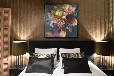 a bedroom with a bed with a painting on the wall at Small Luxury Boutique Hotel Wilma J in Vinkeveen