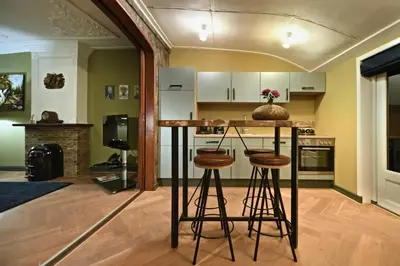a kitchen with a counter and stools in a room at Small Luxury Boutique Hotel Wilma J in Vinkeveen