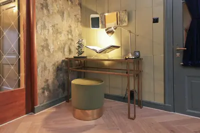 a room with a table and a stool with a lamp at Small Luxury Boutique Hotel Wilma J in Vinkeveen