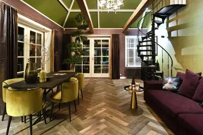 a living room with a purple couch and a table at Small Luxury Boutique Hotel Wilma J in Vinkeveen