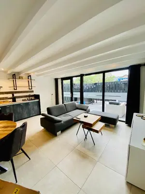 a living room with a couch and a table at Duinzand in Noordwijk aan Zee