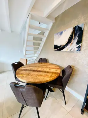a dining room with a wooden table and chairs at Duinzand in Noordwijk aan Zee
