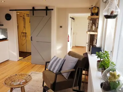 a living room with a couch and a barn door at Southpoint Zandvoort & private parking in Zandvoort