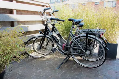 two bikes are parked next to a fence at Southpoint Zandvoort & private parking in Zandvoort