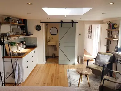 a kitchen with a sliding barn door and a living room at Southpoint Zandvoort & private parking in Zandvoort