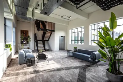 a living room with a couch and chairs and a staircase at Hilversum City Apartments in Hilversum