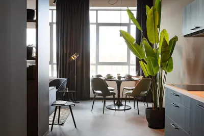 a kitchen with a table with chairs and a plant at Hilversum City Apartments in Hilversum