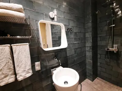 a bathroom with a toilet and a mirror and towels at RoomWest in Amsterdam