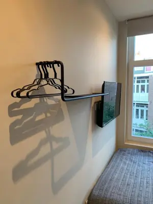 a shelf on a wall next to a window at RoomWest in Amsterdam