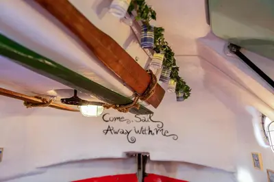 a ceiling with a sign that says come a bit angry whine at PolarStern - unique boatstay! in Monnickendam
