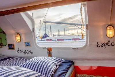 a bed in a boat with a view of a boat at PolarStern - unique boatstay! in Monnickendam