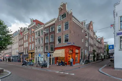a building on a city street with people sitting outside at B&B 1971 Hazenstraat - Shared Bathroom in Amsterdam