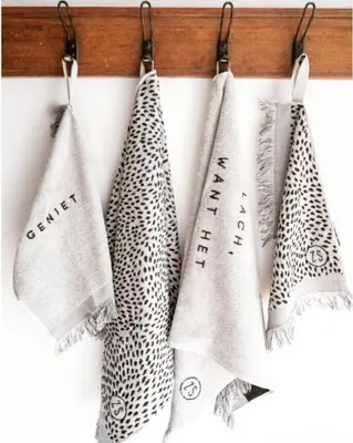 a group of three towels hanging on a rack at Ontbijt bij De Boerenmeid in Hoogwoud